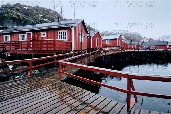 Nusfjord authentic traditional fishing village with traditional red rorbu houses in winter in Norwegian fjord. Lofoten islands