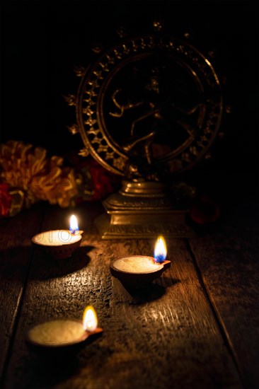 Diwali lights oil candles with Shiva Nataraja in the background for Maha Shivaratri