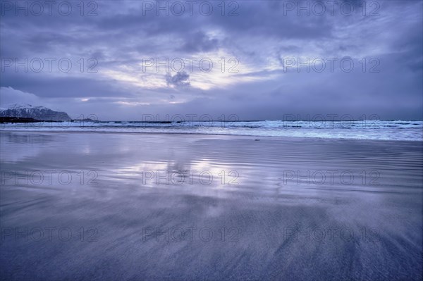 Beach of Norwegian sea on rocky coast in fjord on sunset. Skagsanden beach