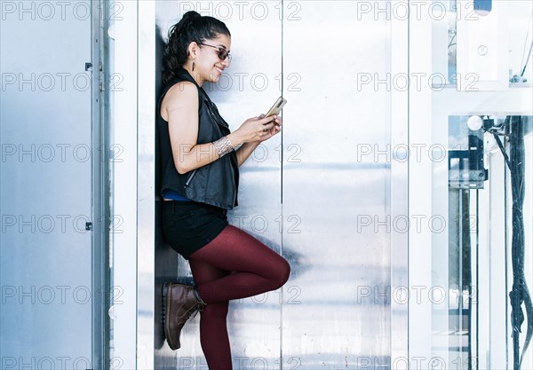 A person texting in the elevator