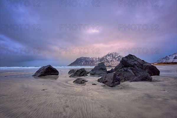 Beach of Norwegian sea on rocky coast in fjord on sunset. Skagsanden beach