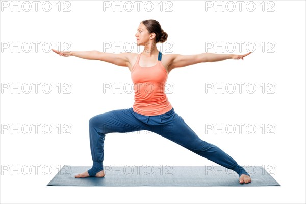 Beautiful sporty fit yogini woman practices yoga asana Virabhadrasana 2