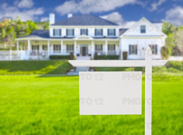 Blank real estate sign in front of beautiful new house