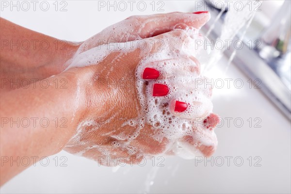 Woman thoroughly washing hands in the sink basin