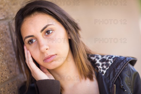 Beautiful meloncholy mixed-race young woman portrait outside