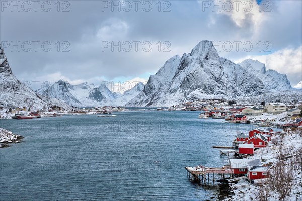 Reine fishing village on Lofoten islands with red rorbu houses in winter with snow. Norway