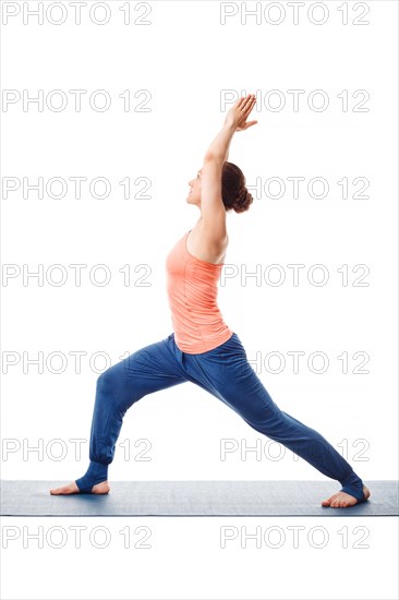 Beautiful sporty fit yogini woman practices yoga asana Virabhadrasana 1