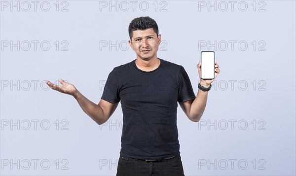 Handsome man smiling positive showing mobile phone blank screen with another hand palm open