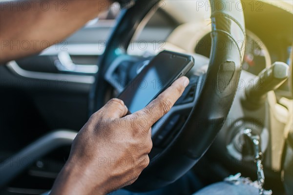 Close up of driver hands using his phone