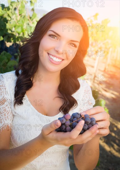 Beautiful young adult woman enjoying A walk in the grape vineyard