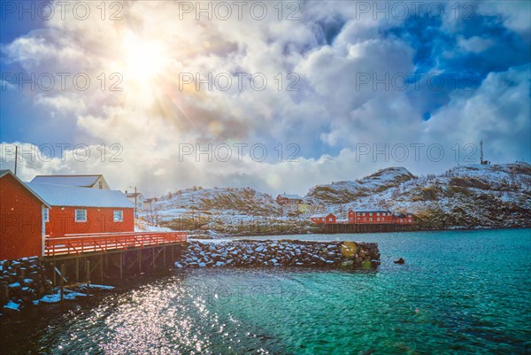 Red rorbu houses of Sakrisoy village with snow in winter. Lofoten islands