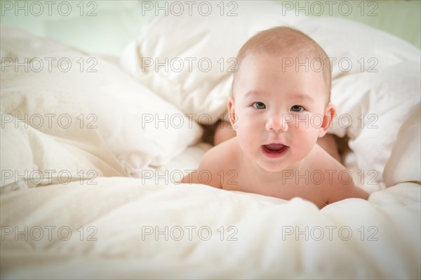 Young mixed-race chinese and caucasian baby boy having fun on his blanket