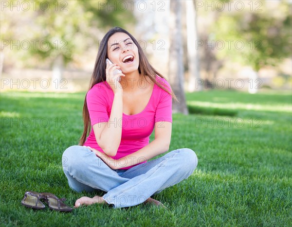 Beautiful young ethnic woman talking on her smartphone outside