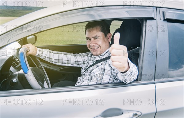 Happy man in his car giving a thumbs up