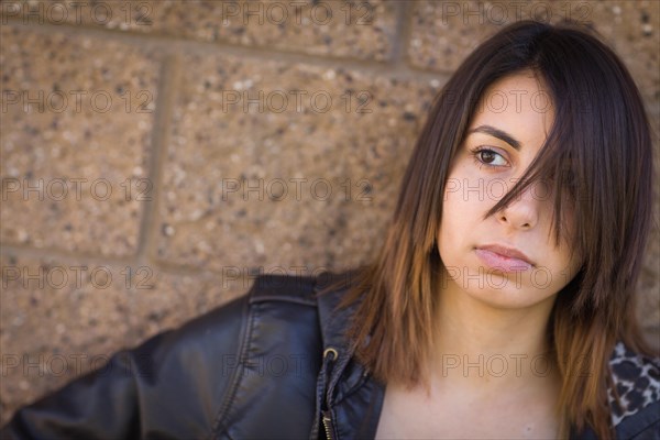 Beautiful meloncholy mixed-race young woman portrait outside