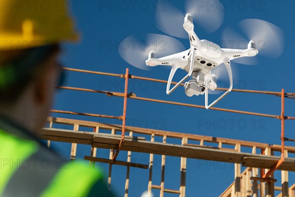 Female pilot flies drone quadcopter inspecting construction site