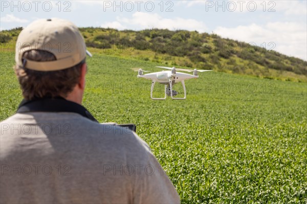 UAV drone pilot flying and gathering data over country farm land