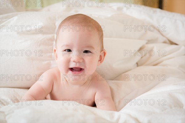 Young mixed-race chinese and caucasian baby boy having fun on his blanket