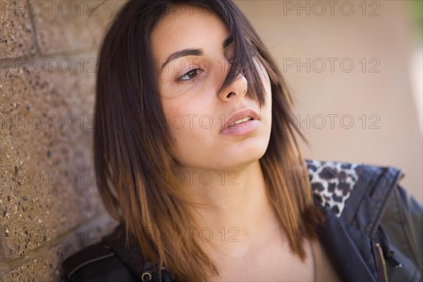 Beautiful meloncholy mixed-race young woman portrait outside