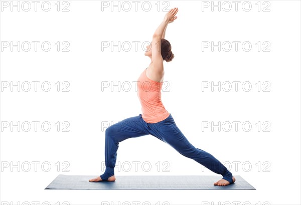 Beautiful sporty fit yogini woman practices yoga asana Virabhadrasana 1