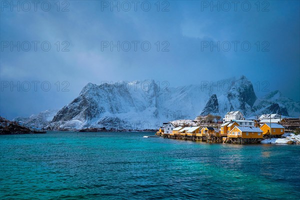 Yellow rorbu houses of Sakrisoy fishing village with snow in winter. Lofoten islands