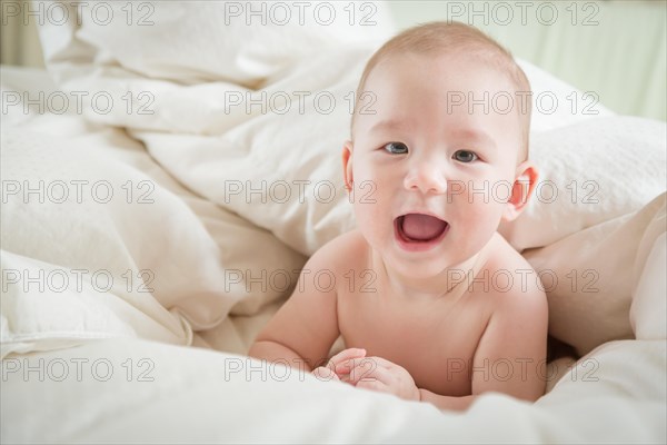 Young mixed-race chinese and caucasian baby boy having fun on his blanket