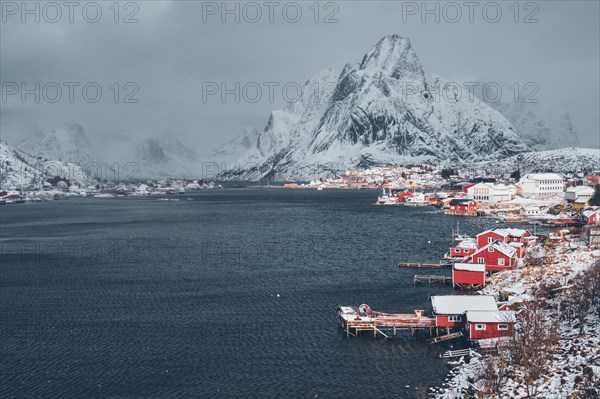 Reine fishing village on Lofoten islands with red rorbu houses in winter with snow. Norway