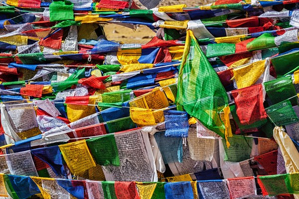 Buddhist prayer flags lungta with mantra Om mani padme hum in tibetan language on Namshang La pass in Himalayas. Ladakh