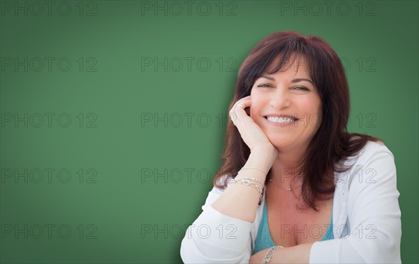 Attractive middle aged woman portrait in front of green chalkboard