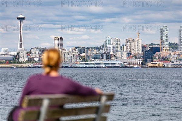 Woman sitting on bench looking at the seattle