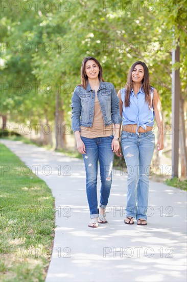 Two beautiful ethnic twin sisters walking outdoors