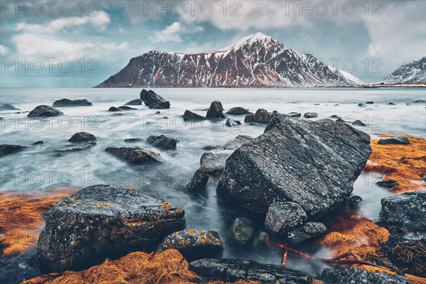 Rocky coast of fjord of Norwegian sea in winter with snow. Skagsanden beach