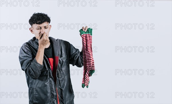 A man with a sock in his hand covering his nose