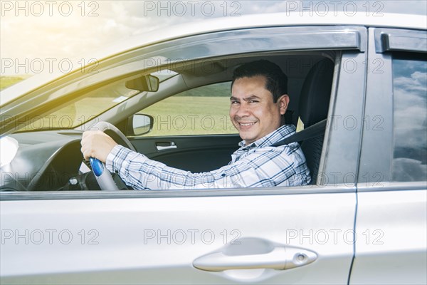 Man smiling at the camera in his car