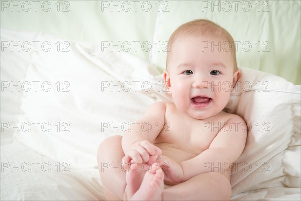 Young mixed-race chinese and caucasian baby boy having fun on his blanket