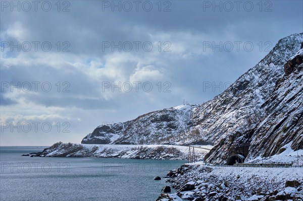 Road with tunnel on coast of a sea in Norway in winter. Lofoten Islands