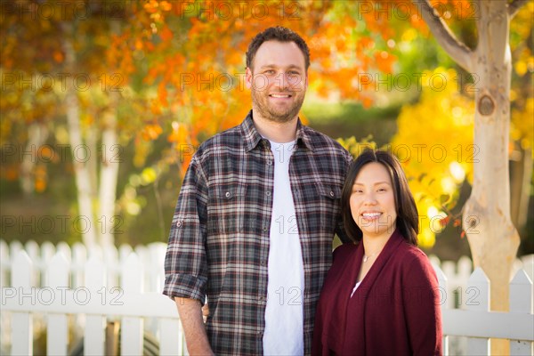 Outdoor fall portrait of chinese and caucasian young adult couple