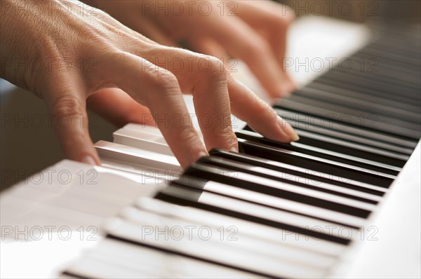 Woman's fingers on digital piano keys