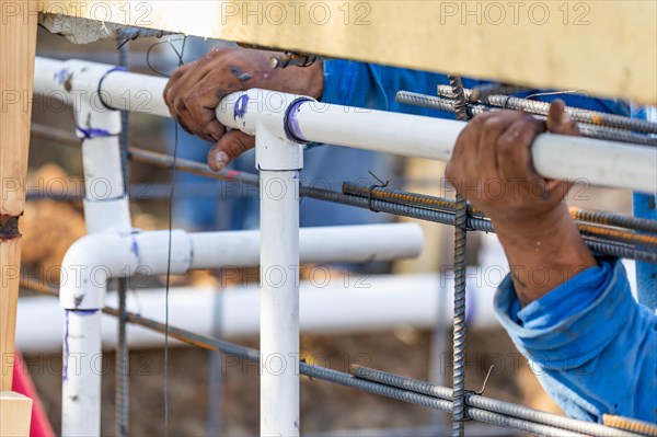 Plumber installing PVC pipe at construction site