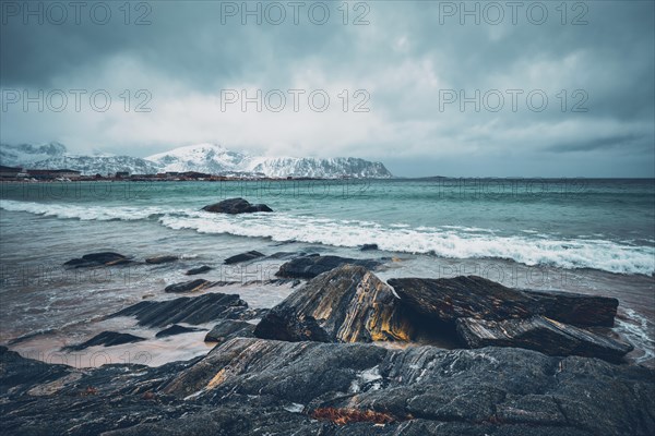 Waves of Norwegian sea on rocky beach of fjord. Ramberg beach