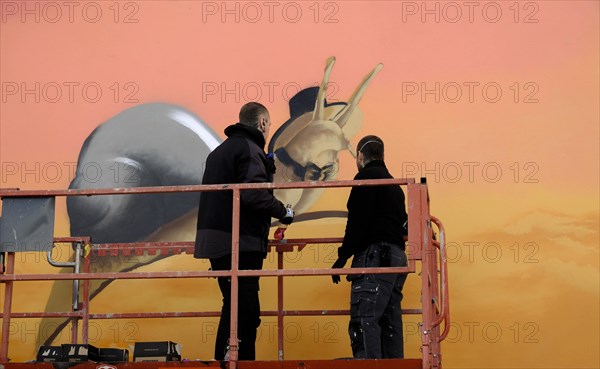 Graffity artist on a lifting platform during a commissioned work