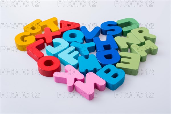 Colorful letter blocks shape heart on white background