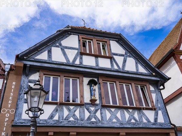 Half-timbered house with wooden figure of Mary with baby Jesus