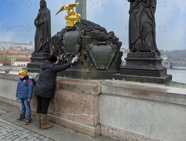 Praying woman with child on Charles Bridge