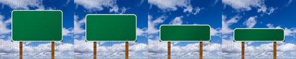 Set of different sized blank green road signs over clouds and blue sky