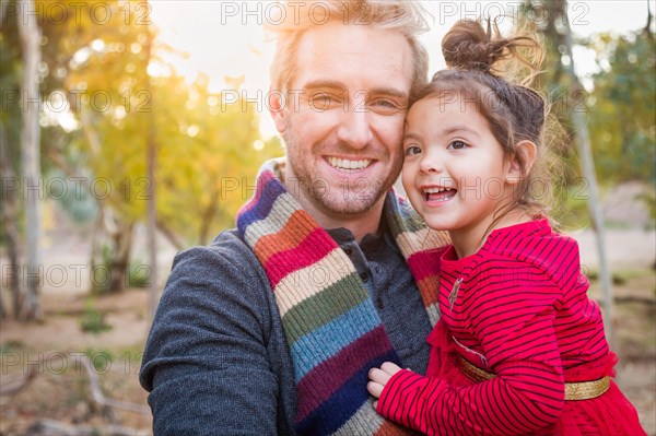 Handsome caucasian young man with mixed-race baby girl outdoors