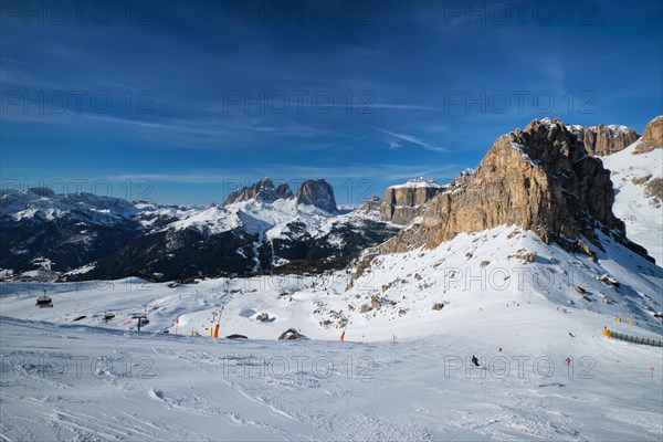 View of a ski resort piste with people skiing in Dolomites in Italy