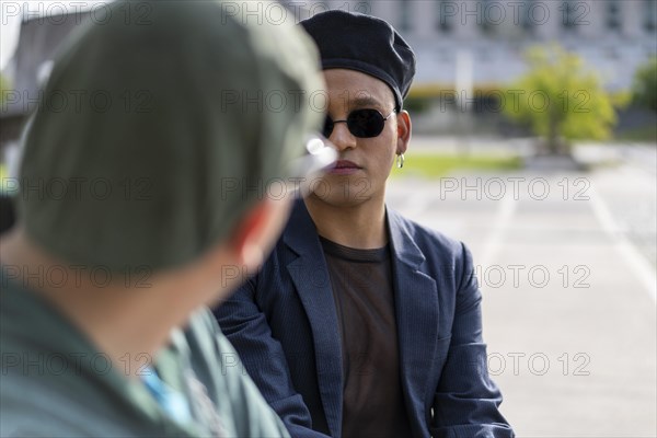 Gay Latino male couple sitting on a bench in a park
