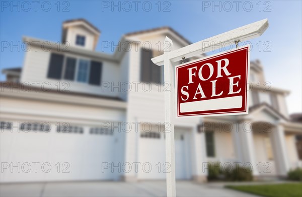 Home for sale real estate sign in front of beautiful new house