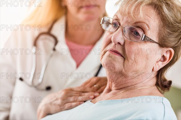 Melancholy senior adult woman being consoled by female doctor or nurse